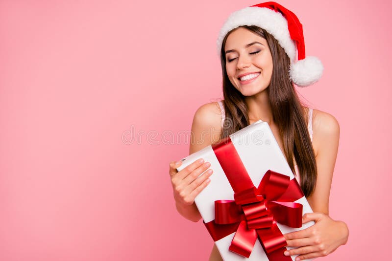 Portrait of nice winsome delighted positive cheerful magnificent sweet straight-haired lady in lingerie and hat, holding, keeping big white gift box, isolated over pink pastel background. Portrait of nice winsome delighted positive cheerful magnificent sweet straight-haired lady in lingerie and hat, holding, keeping big white gift box, isolated over pink pastel background